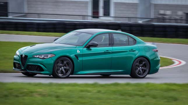 A green Alfa Giulia driving around a racetrack