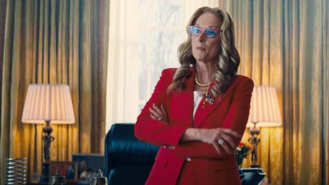 Meryl Streep wears red framed glasses and stands in a red dress suit with her arms crossed in the Oval Office in Don't Look Up.