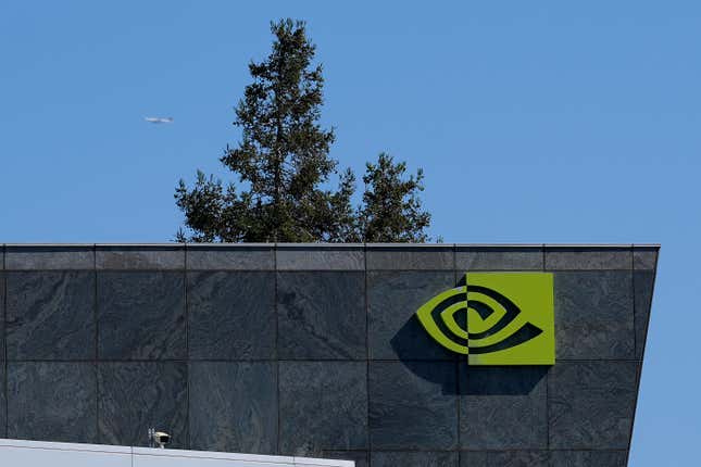 close up of Nvidia logo on corner of grey building, a tree is behind the building and a small plane can be seen in the blue sky background