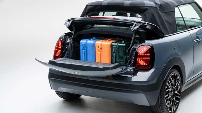 A photo of the trunk of a gray cooper s convertible full of three carryon suitcases