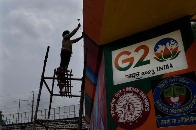 A worker paints an under-construction overhead bridge near the main venue of the G20 Summit, in New Delhi, India, Thursday, Aug. 24, 2023. As India gears up to host the annual gathering of the Group of 20 industrialized and developing nations, the capital city is undergoing an elaborate makeover. But for many street vendors and shantytowns dotting the city, the beautification of New Delhi has meant displacement and loss of livelihoods. (AP Photo/Manish Swarup)