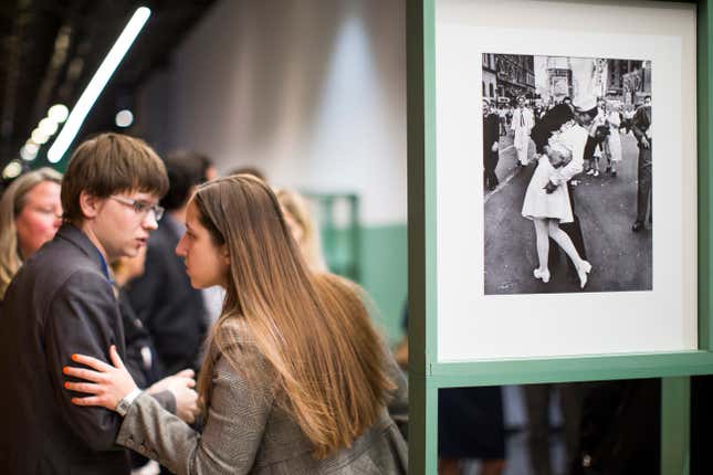 People speak next to a famous photograph taken by Alfred Eisenstaedt of a  sailor kissing a nurse in New York’s Times Square on V-J Day, right, as  they visit the exhibition of German-American Life magazine  photographer Alfred Eisenstaedt at Moscow’s Jewish Museum and Tolerance  Center in Moscow, Russia, Tuesday, April 14, 2015.