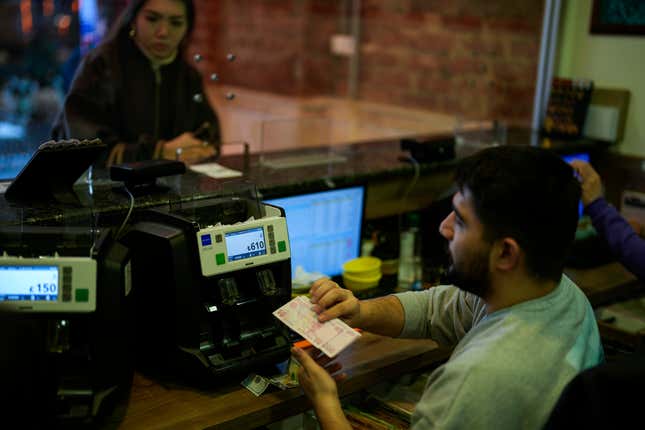 A worker counts Turkish liras banknotes in an exchange currency shop in Istanbul, Turkey, Monday, Feb. 5, 2024. Turkey has seen its fifth central bank leader depart in as many years as Hafize Gaye Erkan, the first woman in the top role, stepped down after just eight months in the job. (AP Photo/Francisco Seco)