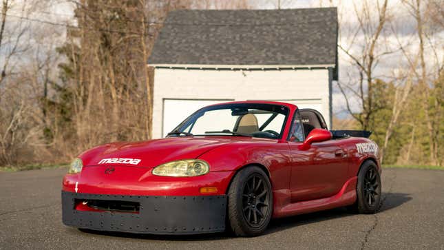 A photo of a track-ready Mazda Miata in red. 