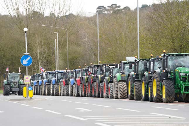 A convoy of farmers in tractors gather on the A20, near Wrotham, in Kent, England, before heading to London to join a protest in Westminster raising awareness of the difficulties for the British farming industry, Monday March 25, 2024. (Gareth Fuller/PA via AP)