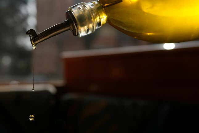 Delia pours olive oil into a salad at the &quot;Gelateria di Pontesesto&quot; Bar, in Rozzano, near Milan, Italy, Friday, March 8, 2024. One-third of Italians have reduced their consumption of extra virgin olive oil due to skyrocketing prices, according to a survey released Friday. But Italian producers are pushing back against the data, saying the snapshot of consumer sentiment does not give a full picture — and that sales of higher-quality Italian extra virgin olive oil are actually up. (AP Photo/Antonio Calanni)