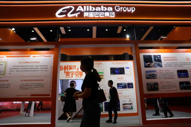 People walk past a booth of Alibaba Group 