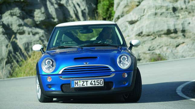 A blue 2004 Mini Cooper S driving around a corner