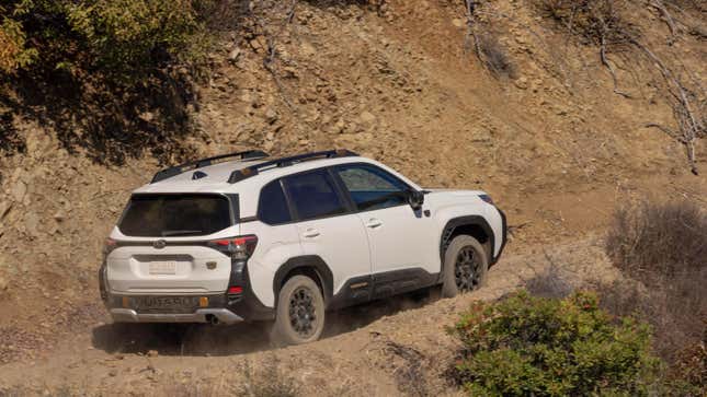 the rear of a white forester wilderness driving up a dirt path