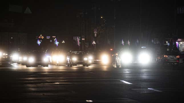 La photo montre des phares lumineux dans une rue sombre lors d’une opération de conservation de l’énergie, le 20 octobre 2022 à Kiev, en Ukraine.