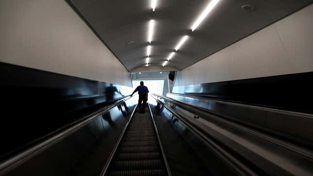 A traveler goes up an escalator at Hartsfield-Jackson Atlanta International Airport