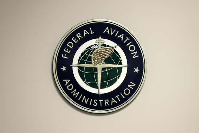 FILE - A Federal Aviation Administration sign hangs in the tower at John F. Kennedy International Airport in New York, March 16, 2017. Congressional negotiators have agreed on a $105 billion bill designed to improve the safety of air travel after a series of close calls between planes at the nation’s airports. (AP Photo/Seth Wenig, File)