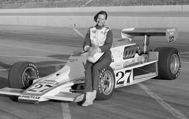 Janet Guthrie poses with an Indy car at Ontario Motor Speedway, 1977