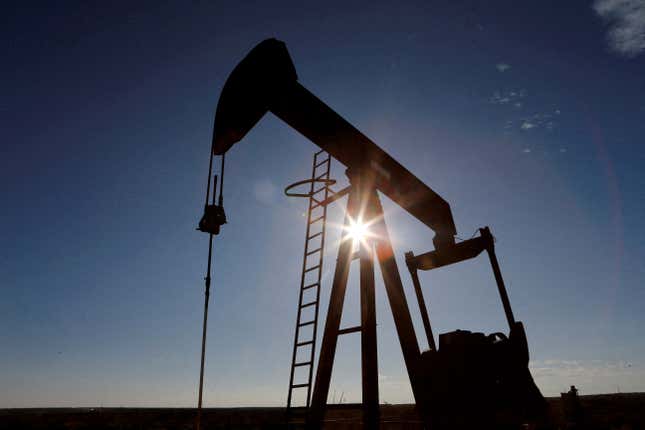 The sun is seen behind a crude oil pump jack in the Permian Basin