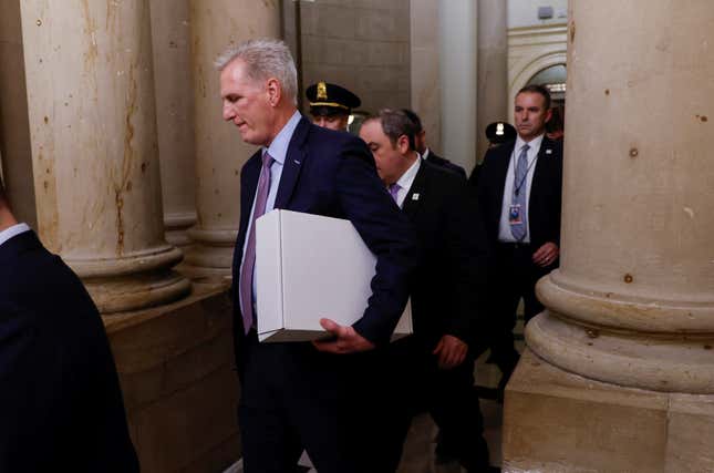 Former Speaker of the House Kevin McCarthy carries a box as he leaves the office of the Speaker of the House and heads out of the US Capitol