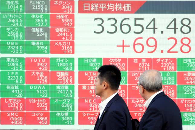 People walk past an electronic stock board showing Japan&#39;s Nikkei 225 index at a securities firm Monday, Nov. 20, 2023, in Tokyo. Asian shares were higher Monday after Wall Street closed its third straight winning week with a tiny gain. (AP Photo/Eugene Hoshiko)