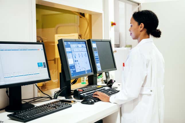 A doctor standing while using a computer in the radiology department at hospital.