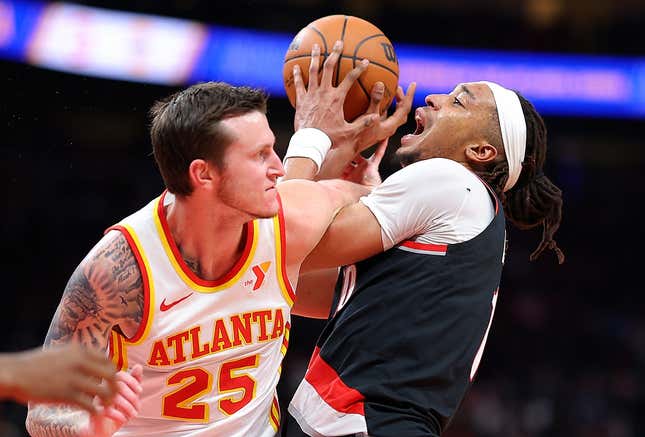 ATLANTA, GEORGIA - MARCH 27:  Moses Brown #10 of the Portland Trail Blazers draws a foul from Garrison Mathews #25 of the Atlanta Hawks during the second quarter at State Farm Arena on March 27, 2024 in Atlanta, Georgia.  NOTE TO USER: User expressly acknowledges and agrees that, by downloading and/or using this photograph, user is consenting to the terms and conditions of the Getty Images License Agreement.  (Photo by Kevin C. Cox/Getty Images)