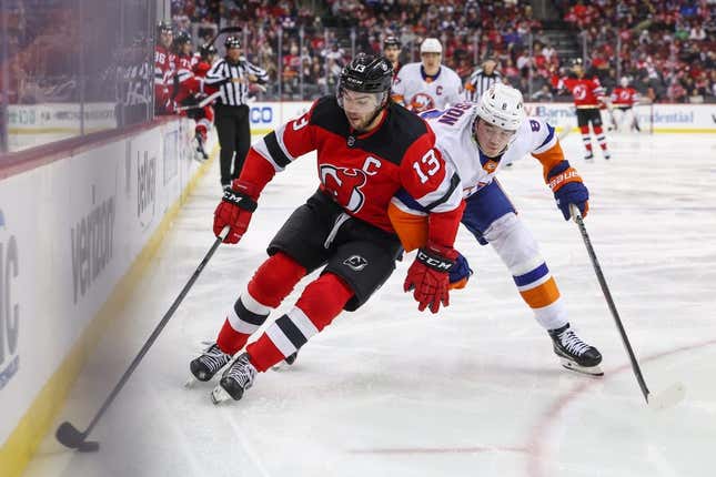 Nov 28, 2023; Newark, New Jersey, USA; New Jersey Devils center Nico Hischier (13) skates with the puck while being defended by New York Islanders defenseman Noah Dobson (8) during the second period at Prudential Center.
