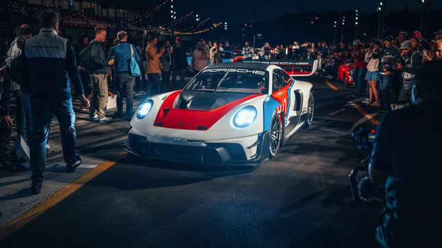 Porsche's 911 GT3 R Rennsport is parked in a crowd of people with its headlights on