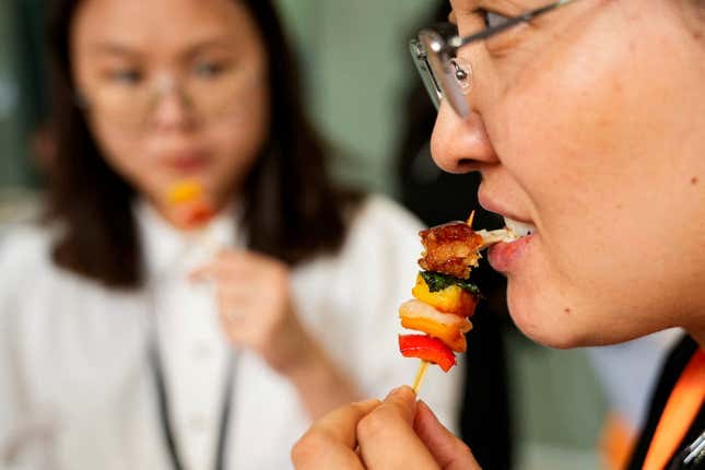Woman eats skewer of lab-grown meat