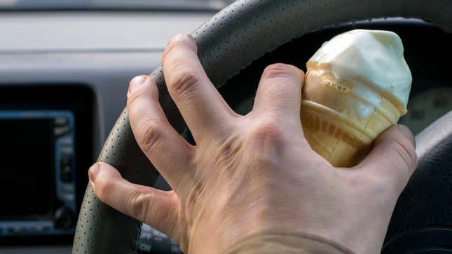驱动手握冰淇淋和单手方向盘