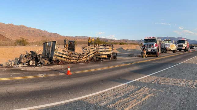 The burnt-out stake-bed truck waiting to be cleared from the roadway.