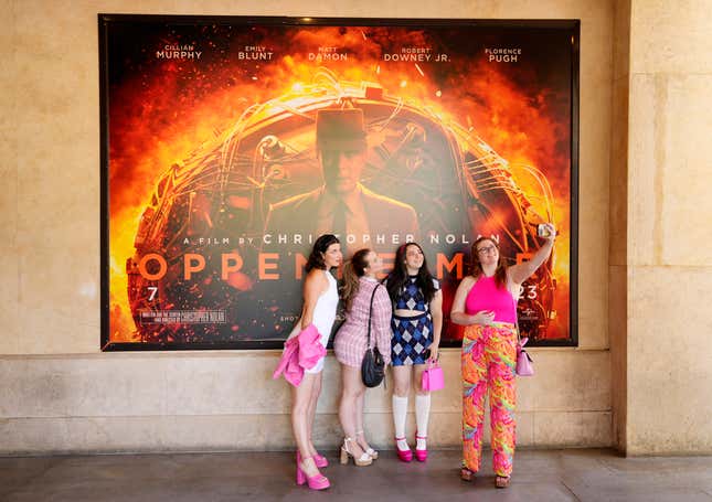 From left, Gabrielle Roitman, Kayla Seffing, Maddy Hiller and Casey Myer take a selfie in front of an &quot;Oppenheimer&quot; movie poster before they attended an advance screening of &quot;Barbie,&quot; Thursday, July 20, 2023, at AMC The Grove 14 theaters in Los Angeles. (AP Photo/Chris Pizzello)