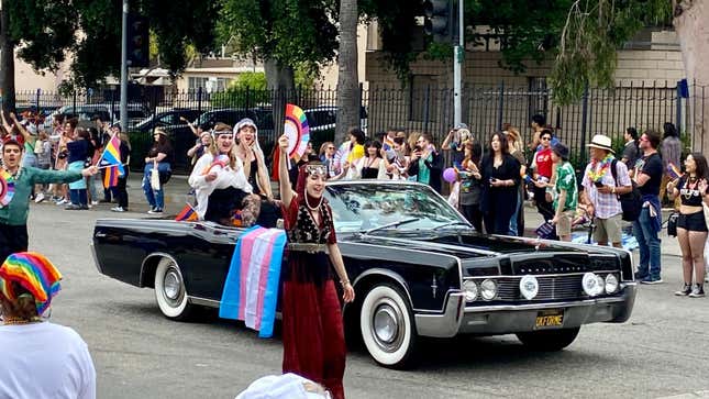 Ein schwarzes Lincoln Continental Cabrio mit einer über der Seite hängenden Transgender-Flagge