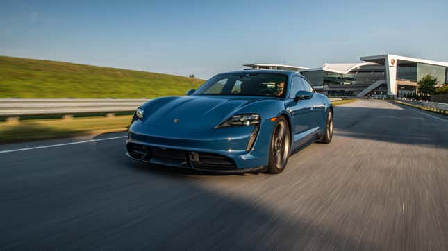 A blue Porsche Taycan Turbo S driving up a road