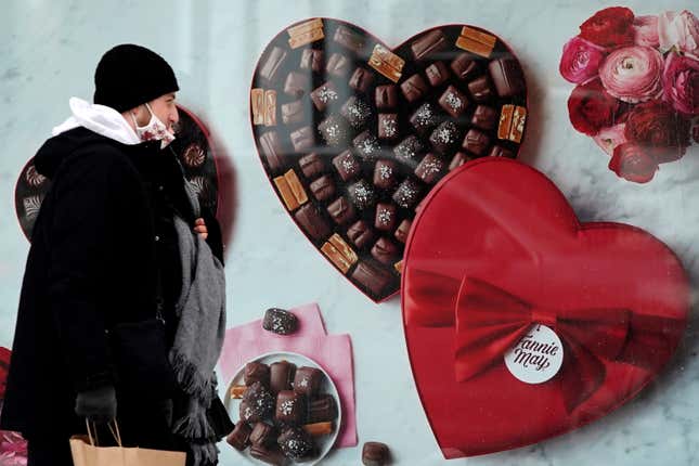 FILE - A man passes a Fannie May chocolate shop in downtown Chicago on Valentine&#39;s Day, Feb. 14, 2021. Valentine&#39;s Day is meant to celebrate romance and the depths of feeling we have for loved ones. So it may be surprising how much Valentine&#39;s shopping is done at the last minute. (AP Photo/Nam Y. Huh, File)