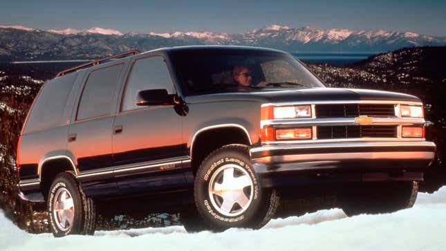 A photo of a black Chevrolet Tahoe SUV driving over snow. 