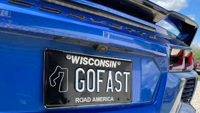 A photo of a black Road America license plate fitted to a car. 