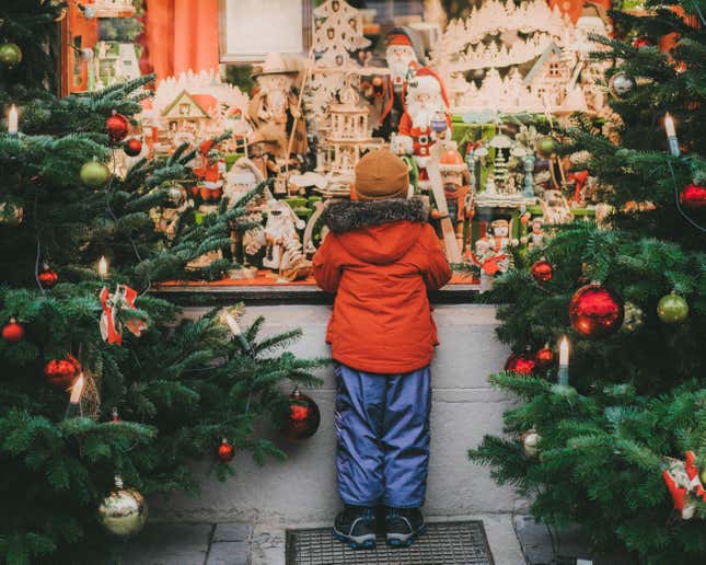 A boy standing near Christmas tree in Rothenburg in winter. 