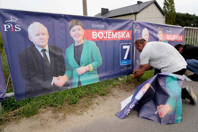 A man puts up election banners for a candidate of the ruling conservative Law and Justice party, including an image of the party leader and Poland&#39;s de-facto leader Jaroslaw Kaczynski, in Czosnow near Warsaw, on Wednesday, Oct. 11, 2023. The Poles are voting in key parliamentary elections on Sunday that will decide whether Law and Justice wins a third consecutive term, or the pro-European opposition forms the new government. AP Photo/Czarek Sokolowski)