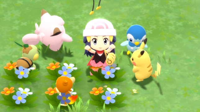 A Pokémon trainer cheers in a field while surrounded by Pokémon.