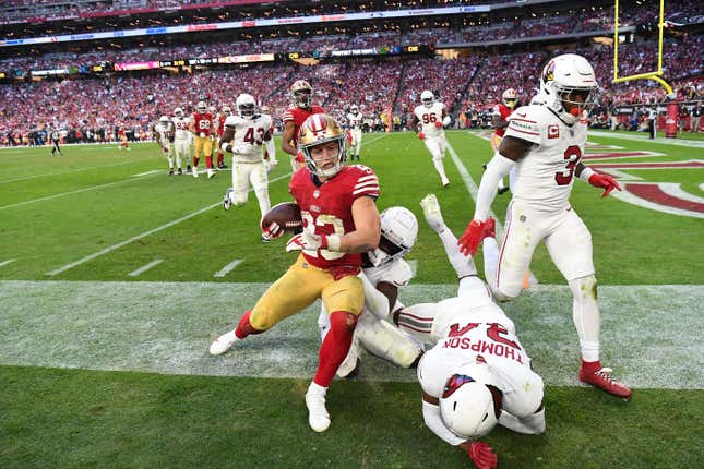 GLENDALE, ARIZONA - DECEMBER 17: Christian McCaffrey #23 of the San Francisco 49ers is forced out of bounds by slew of Arizona Cardinals defenders during the fourth quarter at State Farm Stadium on December 17, 2023 in Glendale, Arizona. (Photo by Norm Hall/Getty Images)