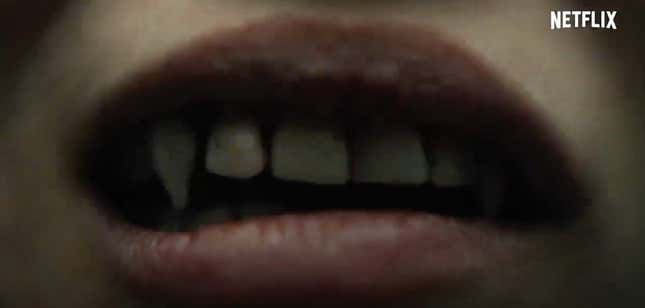 A woman's teeth begin to sprout fangs in this screengrab from Netflix vampire action movie Blood Red Sky.