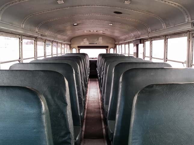 The interior of a school bus looking toward the back door