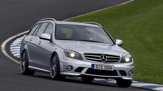 A silver S204 C63 AMG driving around a track from the front 3/4 view