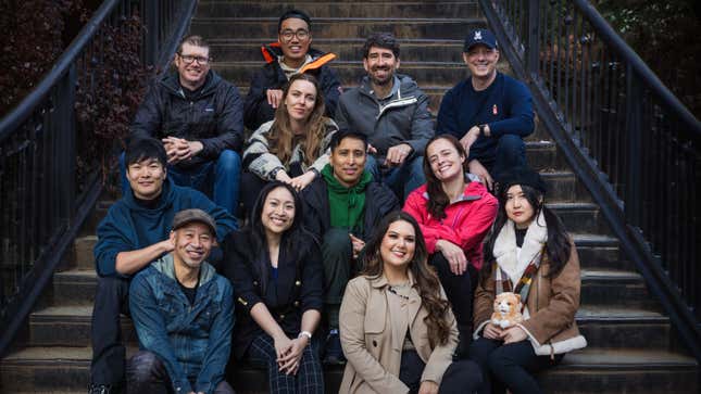 The Worlds Untold team is pictured on a set of stairs.