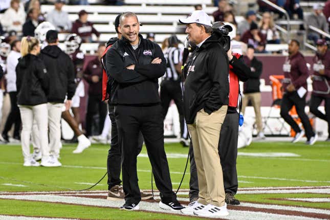 Jimbo Fisher (r.) chatting with Zach Arnett, possibly about how Fisher is going to spend his millions in severance.