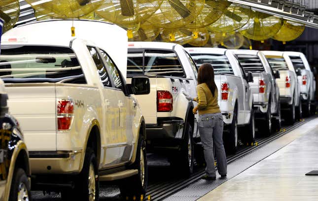 An employee checks a line of white 2009 Ford F-150s on the assembly line at Ford's Kansas City Assembly Plant