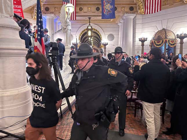 Police arrest some of about 200 people taken into custody on Monday, Feb. 5, 2024, in the Rotunda of the State Capitol in Harrisburg, Pennsylvania. The arrests shut down a demonstration against the state Treasury Department&#39;s investment of about $56 million in Israel bonds. The protest was organized by Jewish Voice for Peace, the Philly Palestine Coalition and the Pennsylvania Council on American-Islamic Relations. (AP Photo/Mark Scolforo)