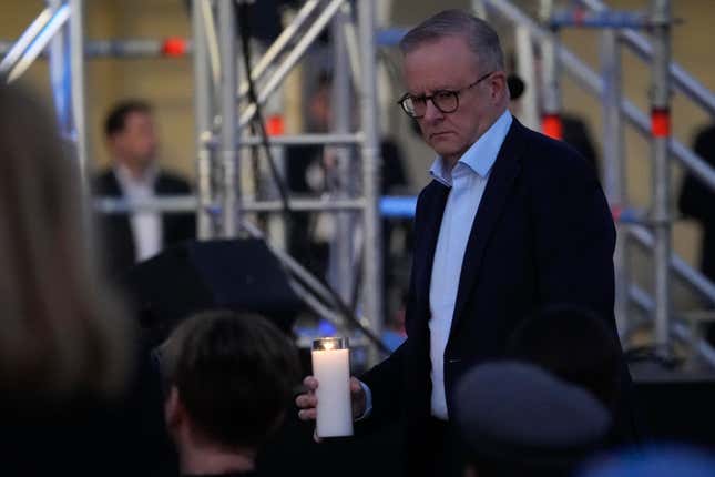 Australian Prime Minister Anthony Albanese carries a candle during a candlelight vigil at Sydney&#39;s Bondi Beach to remember victims of a knife attack at a nearby shopping mall, Australia, Sunday, April 21, 2024. An assailant was shot and killed by a police officer on April 13, after he stabbed six people to death and wounded more than a dozen others in an attack that police believe targeted women. (AP Photo/Mark Baker)