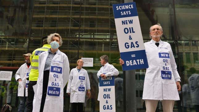 Activists hold signs calling for no new fossil fuel projects outside the UK Department for Business, Energy and Industrial Strategy during a protest on April 13, 2022