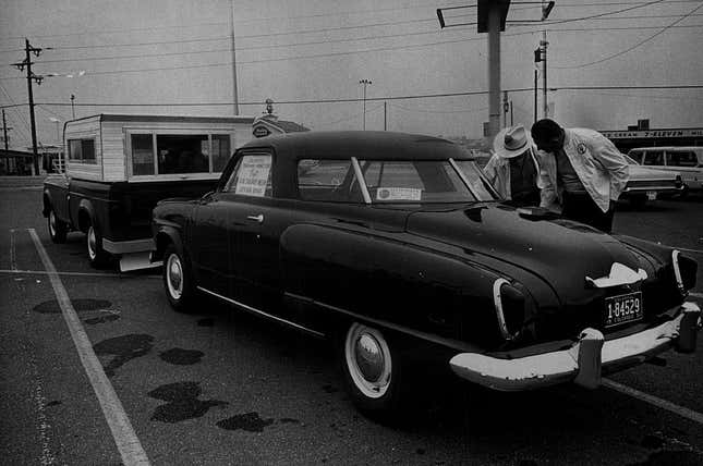 A vintage photo of a '51 Studebaker Starlite coupe from behind. Its rear windows make it look more like a front windshield