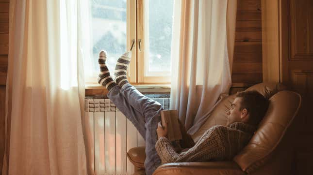 man relaxing in a chair reading a book