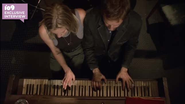 Starbuck (Katee Sackhoff) and a stranger (Roark Critchlow) play "All Along the Watchtower" on a piano in Battlestar Galactica.