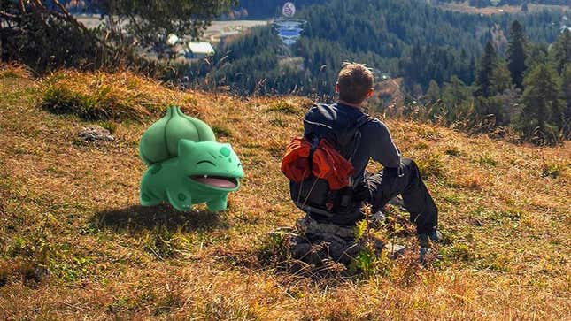 A man sits on a hill overlooking a forest with a smiling Bulbasaur nearby.